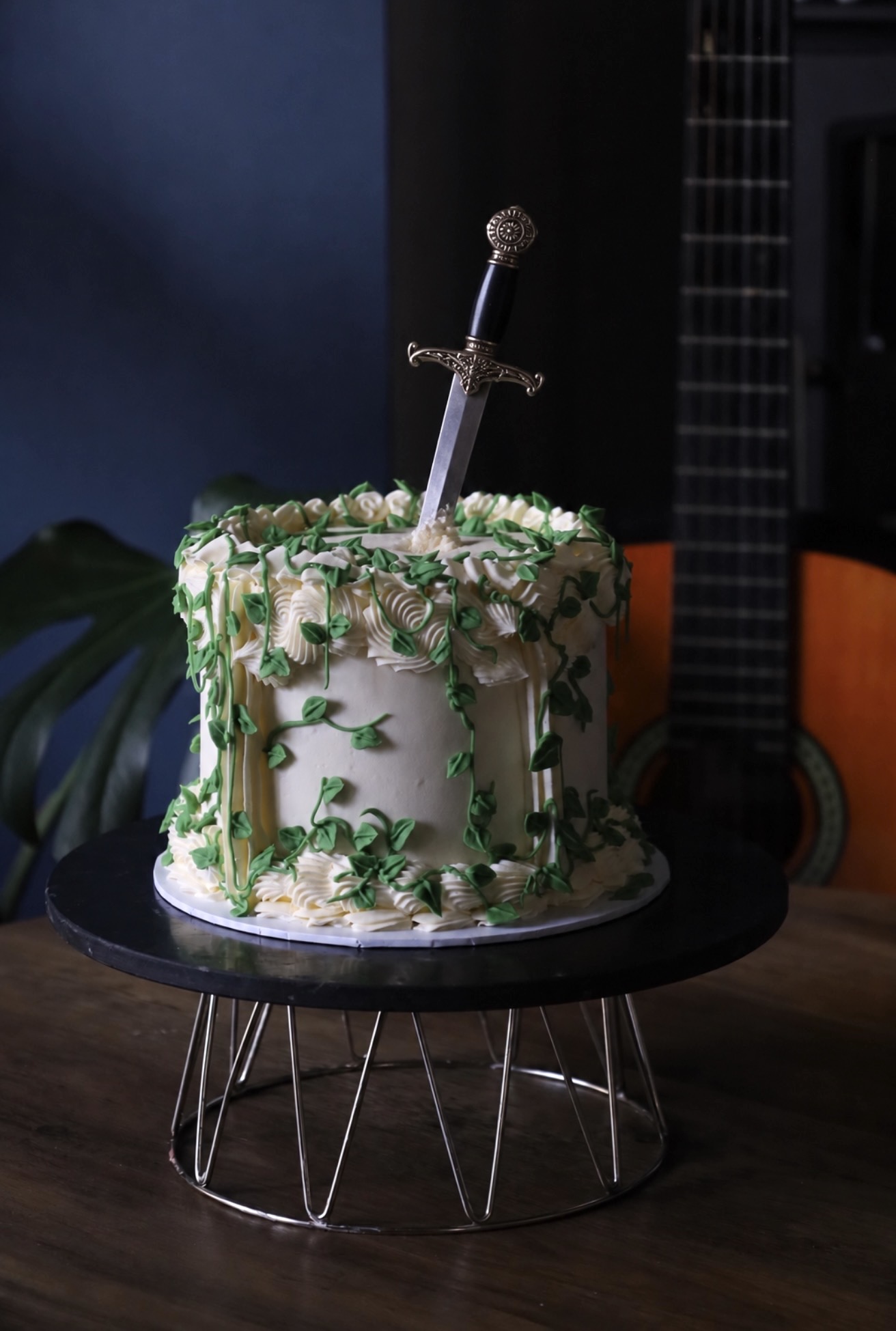 Green ivy celebration cake with sword topper