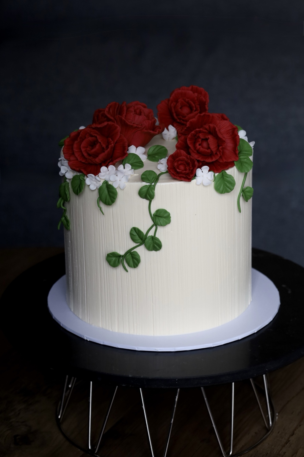 White celebration cake with red sugar roses